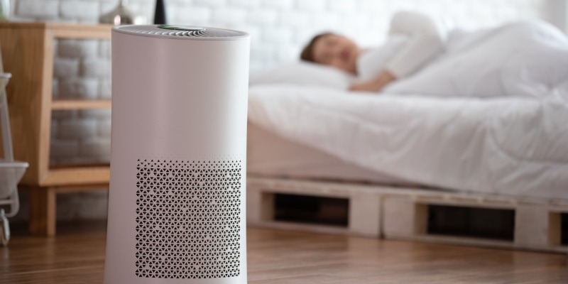 woman sleeping in bed with air purifier on