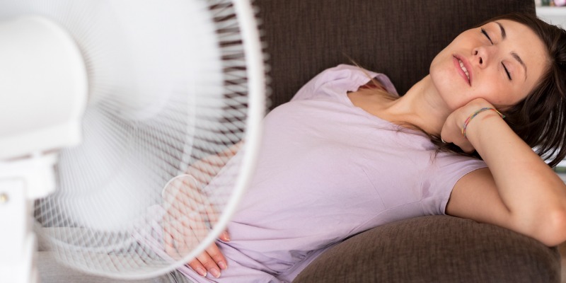 woman sitting in front of fan