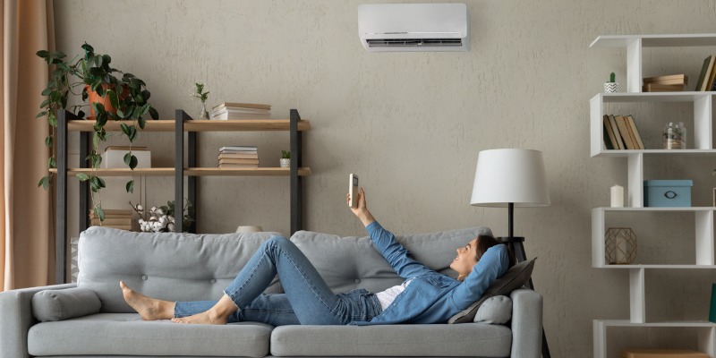 Women turning on ductless AC unit
