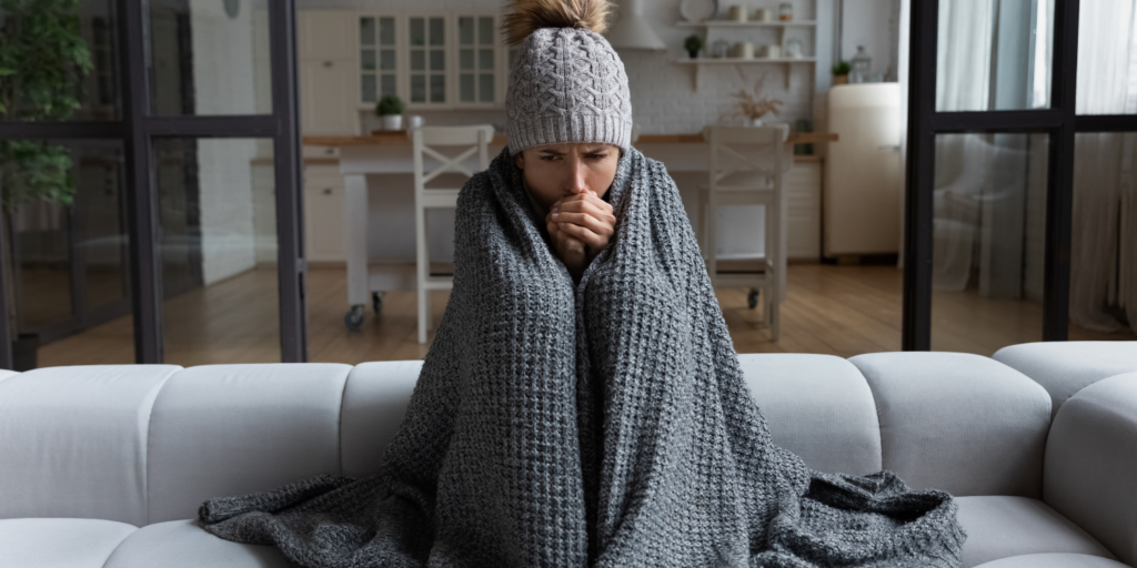 Lady At Home On Couch During A Cold Snap - Understanding HVAC Emergencies: How to Know When to Call the Pros